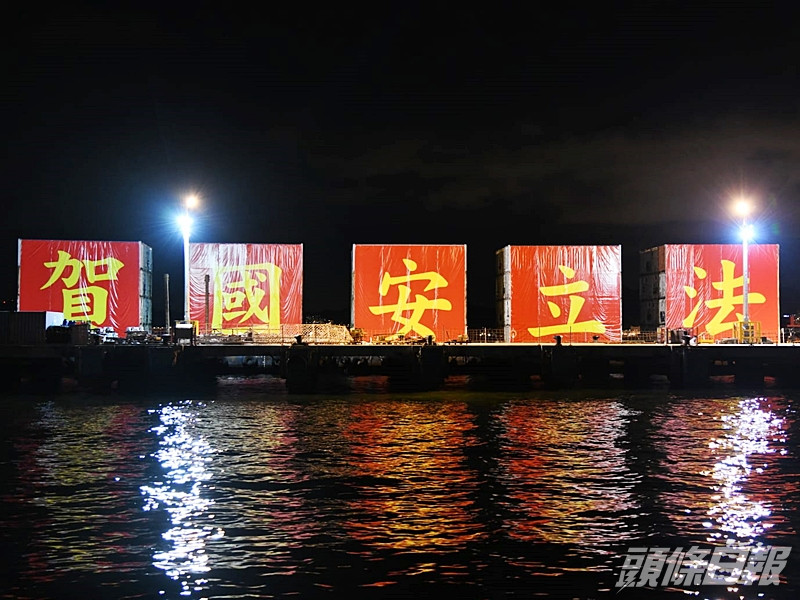 於西環堅尼地城招商局對出碼頭,有人發現一堆貨櫃上豎立紅底黃字的「賀國安立法」大字。