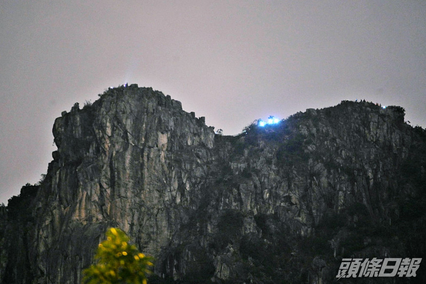 獅子山頂過百人亮燈叫示威口號。