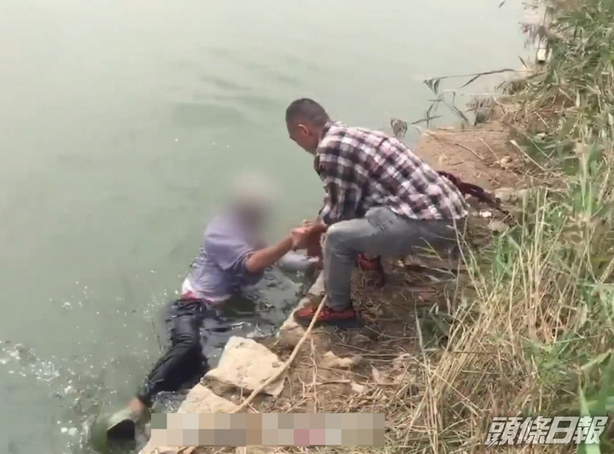 少年請求路邊的成年人幫忙,將老人拉上岸。影片截圖