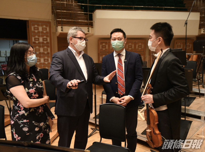 徐英偉(右二)聽取霍品達(左二)介紹樂團的工作。政府新聞處圖片