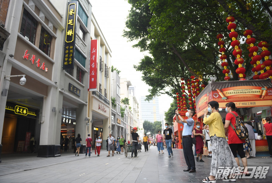 旅客在廣州北京路步行街拍照。 新華社