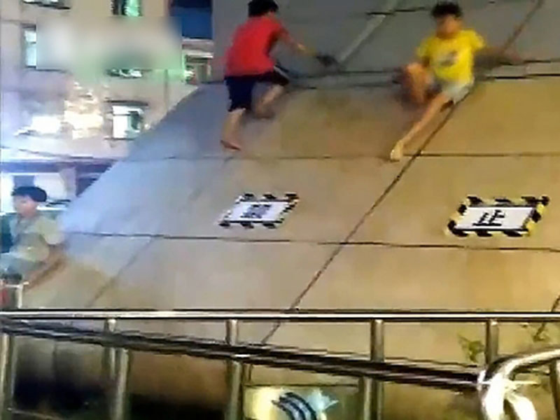 頑童將南寧一個地鐵站出入口的斜坡,當成滑梯,無視禁止攀爬的告示。(網圖)