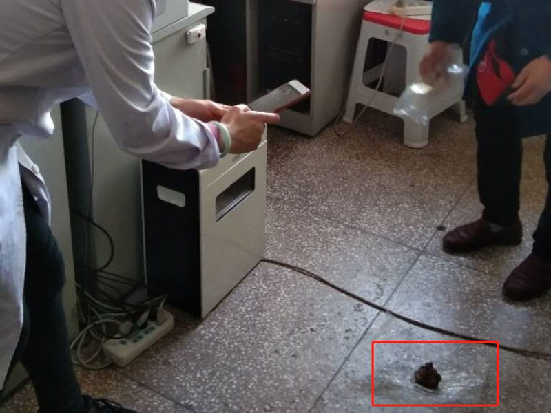 有工作人員對著一塊發黑、成團狀的紗布拍照。(網圖)