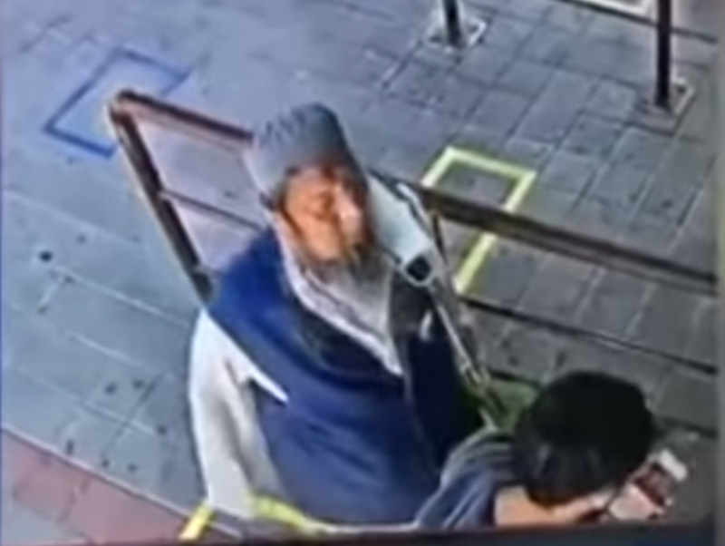 泰國大叔(戴帽者)排隊買票對人吐口水,其後暴斃火車上,事後驗出確診。(網圖)
