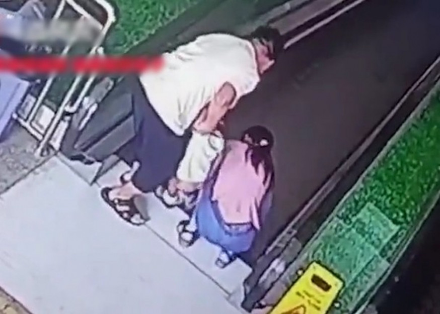 廣西男子低頭玩手機,兒子衣服捲扶手電梯縫隙險釀禍。(網圖)