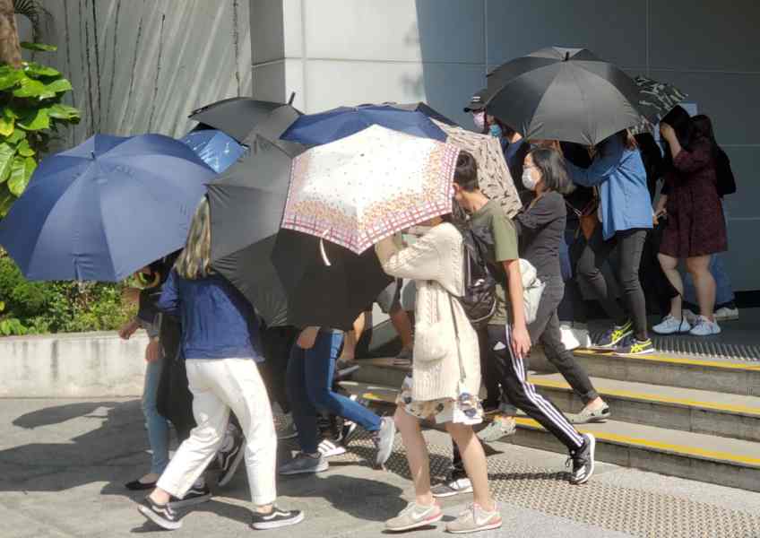 被告鄧智樂在傘陣掩護下離開法院。蕭文軒攝