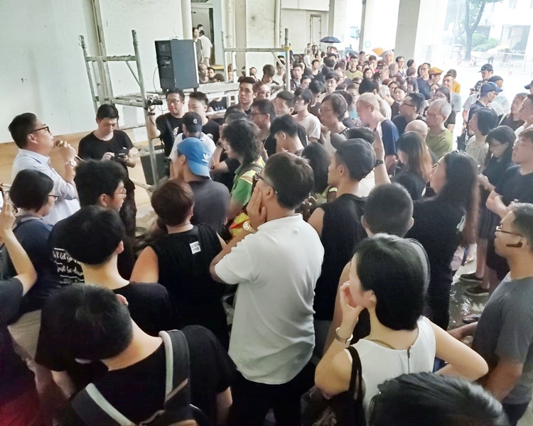 蘇冠成(左,淺色上衣)在場向居民解釋。