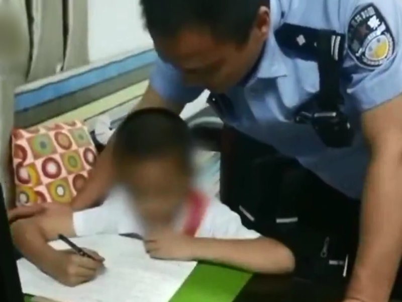 警員在等待男童祖母接領孩子期間,更輪流給他輔導功課。 影片截圖