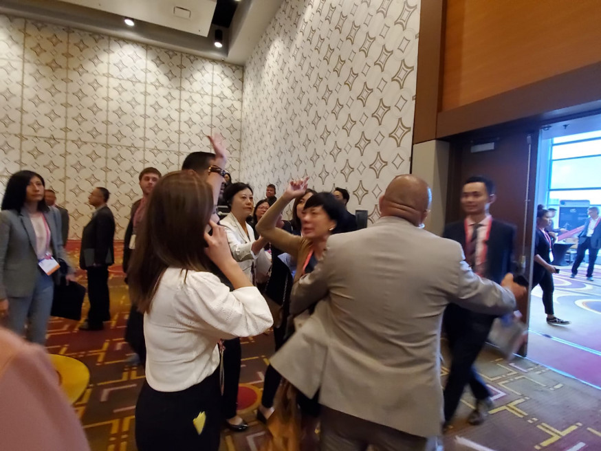三名與會華人,在場內高叫「光復香港,時代革命」、「Democracy Now」被保安拉離場。