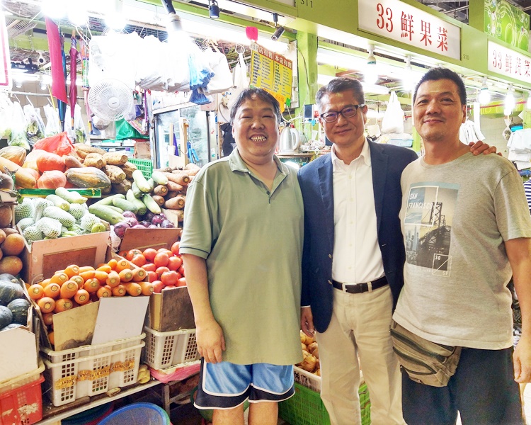 陳茂波(中)昨天到灣仔與街市檔主、店員和買餸的市民聊天。