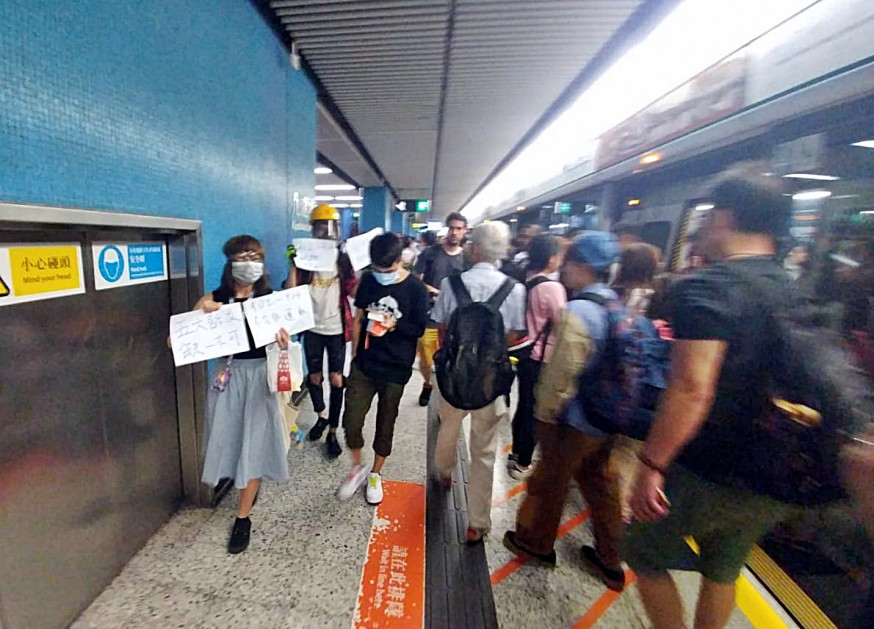有年輕人在站內向乘客展示寫有「毋忘元朗721」、「五大訴求,缺一不可」的標語。