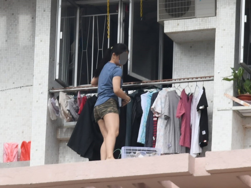 同屋女成員又爬出簷篷,撿回膠盒等雜物。