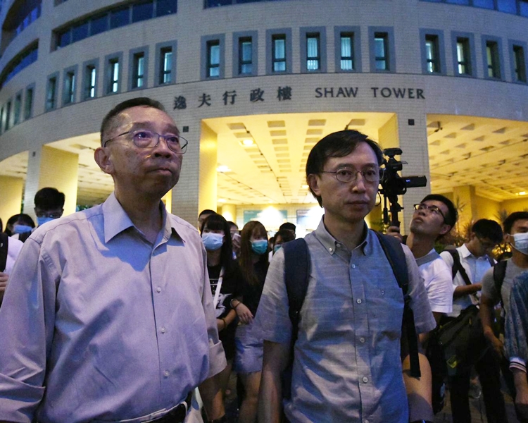 協理副校長(學生體驗)麥福達(左)與新聞系系主任劉志權赴警署。